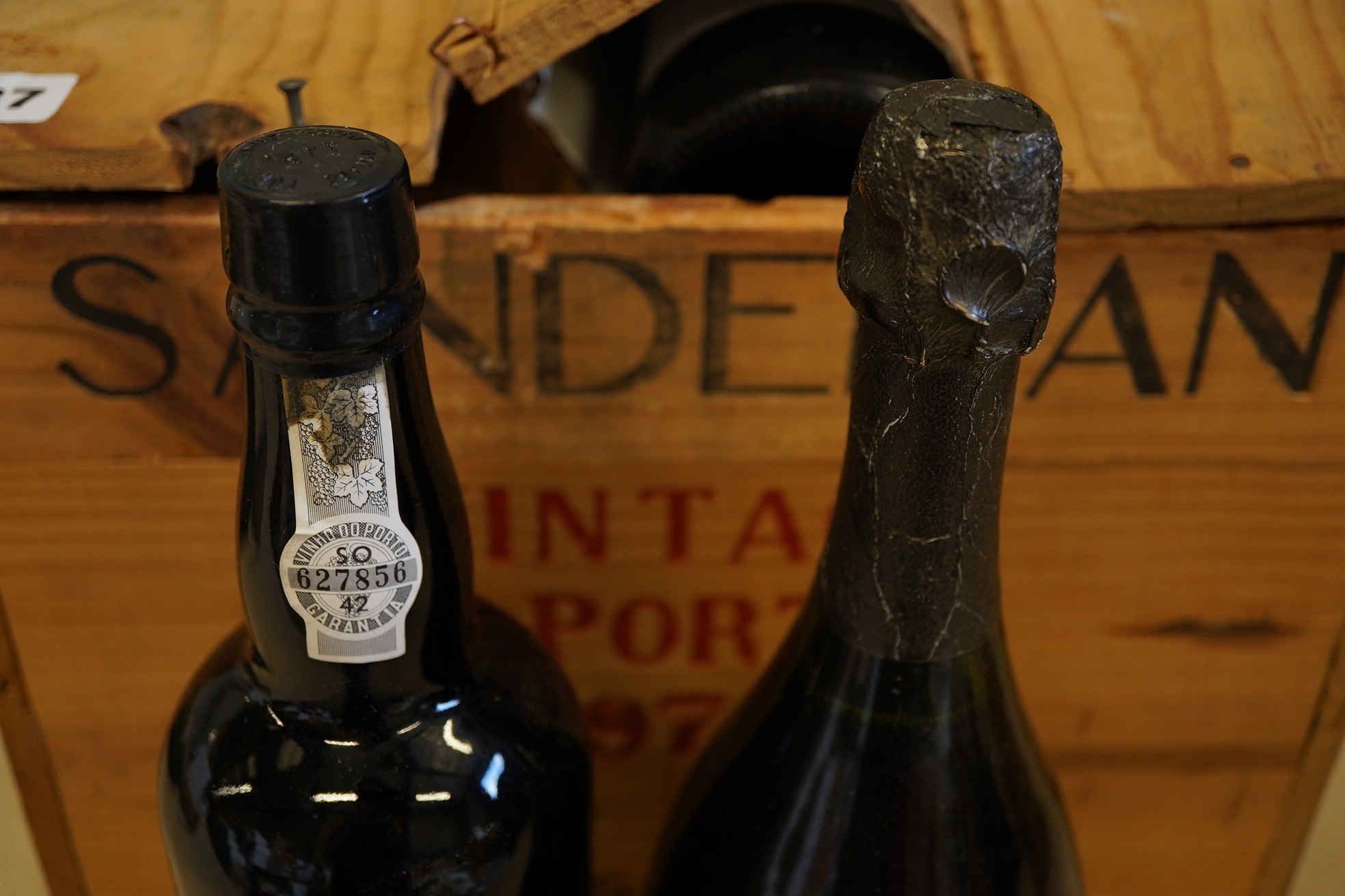 Twelve bottles of 1977 Sandeman vintage port (O.W.C but opened), and a cased bottle of 1978 Dom Perignon champagne